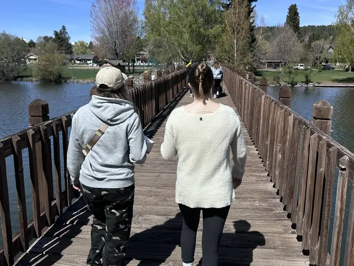 Two people walking across a footbridge in Bend, Oregon