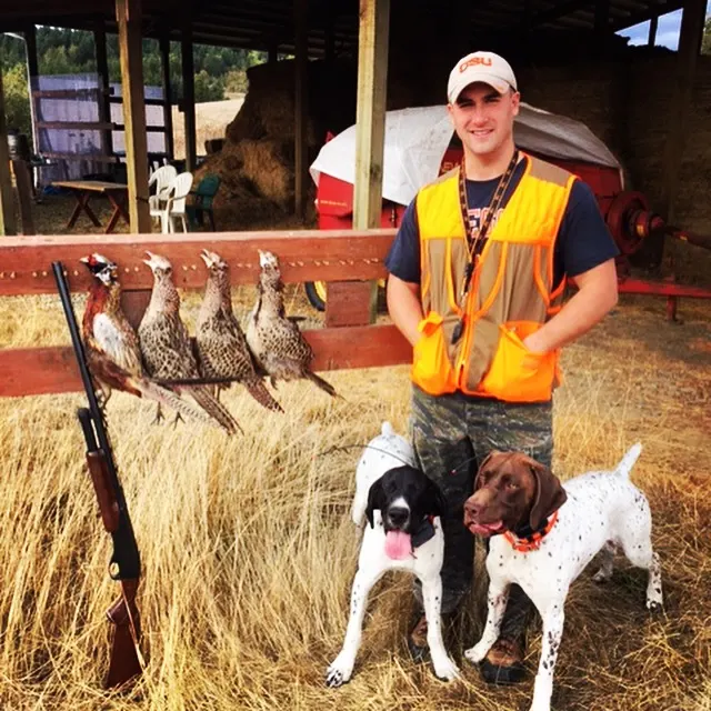 A hunter with bird dogs and pheasants at White River Outfitters