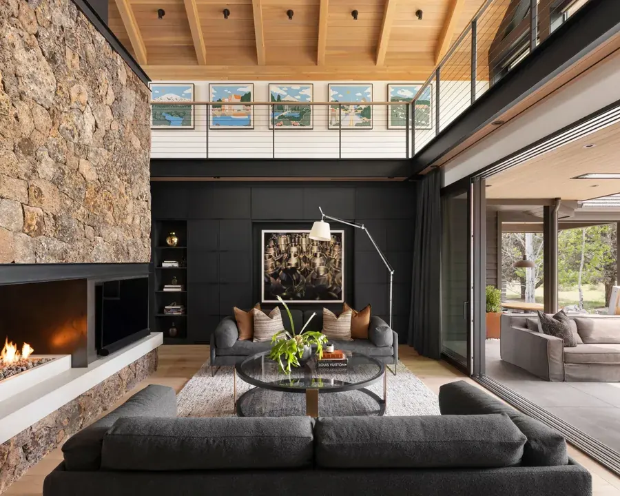 A living room with a stone fireplace wall and wood ceiling designed by Design Bar in Bend