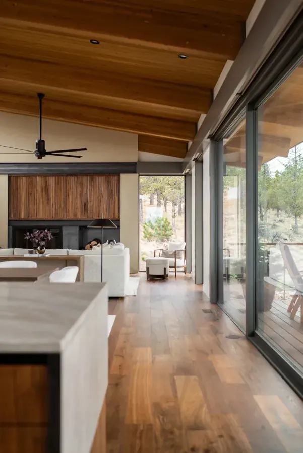 A kitchen and hallway with warm wood floors and ceilings by Julanda Shannon Design in Central Oregon