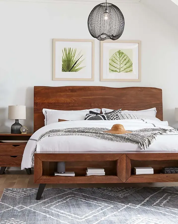 A wood bed and framed art in a bedroom setting from NW Home Interiors in Bend