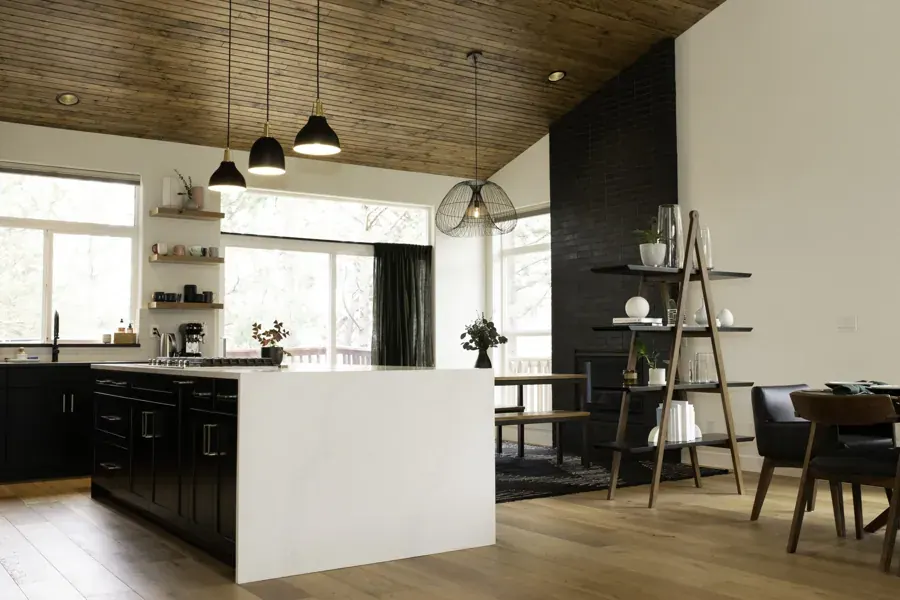 A kitchen with black cabinets and a wood ceiling designed by Society West Design in Bend