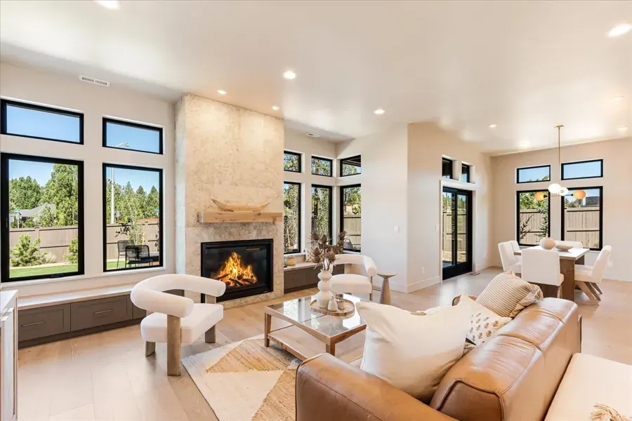 A staged living room with a tiled fireplace and leather sofa by Wyatt Jane Design in Bend