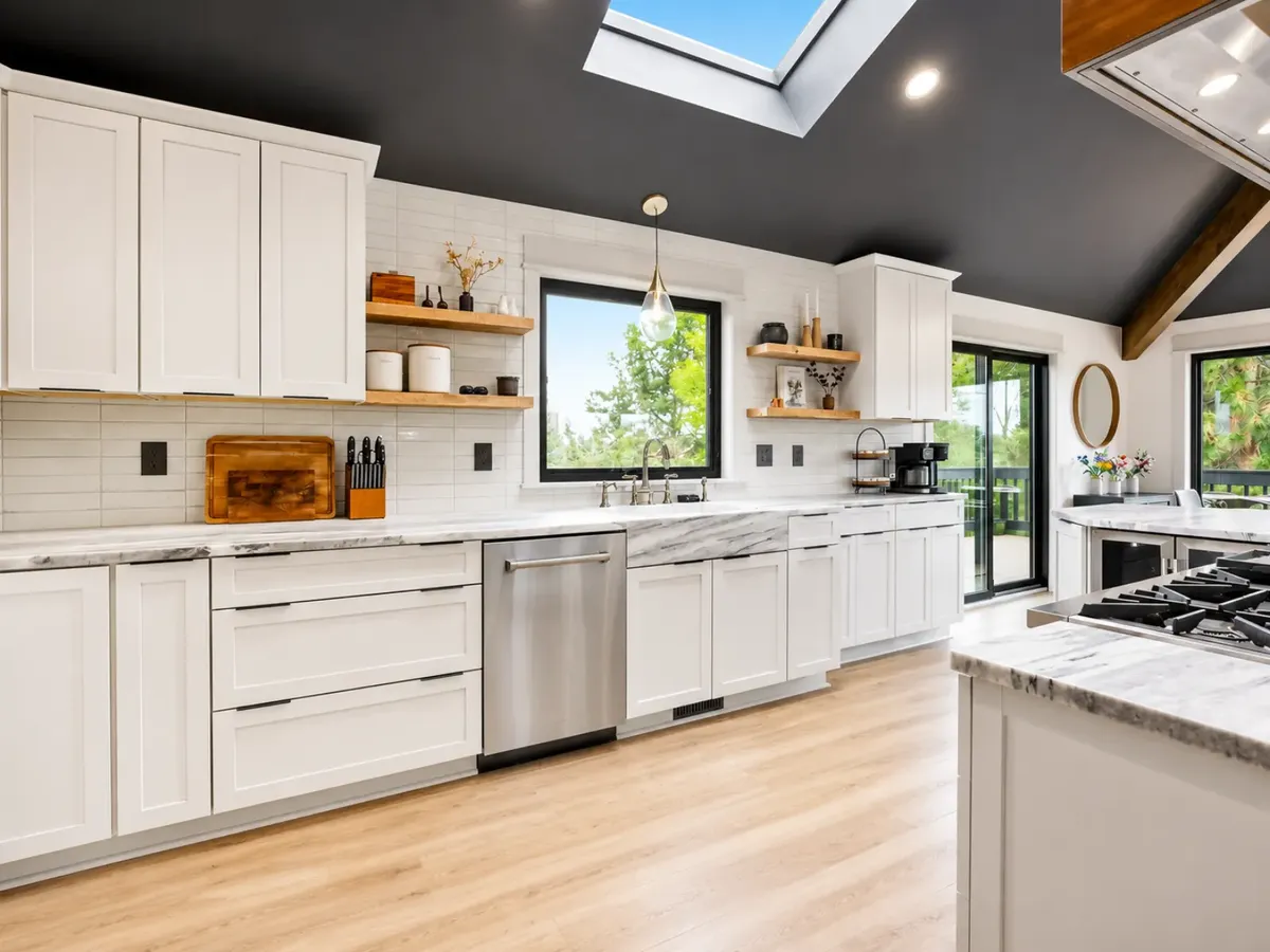 White kitchen with skylights, open shelves and leather stools by Almog Construction