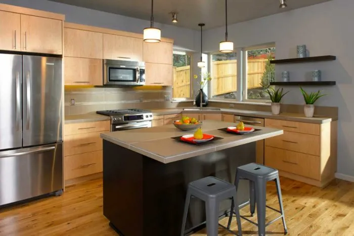 Light wood kitchen with an island and stainless appliances by Bend Craftsmen Company