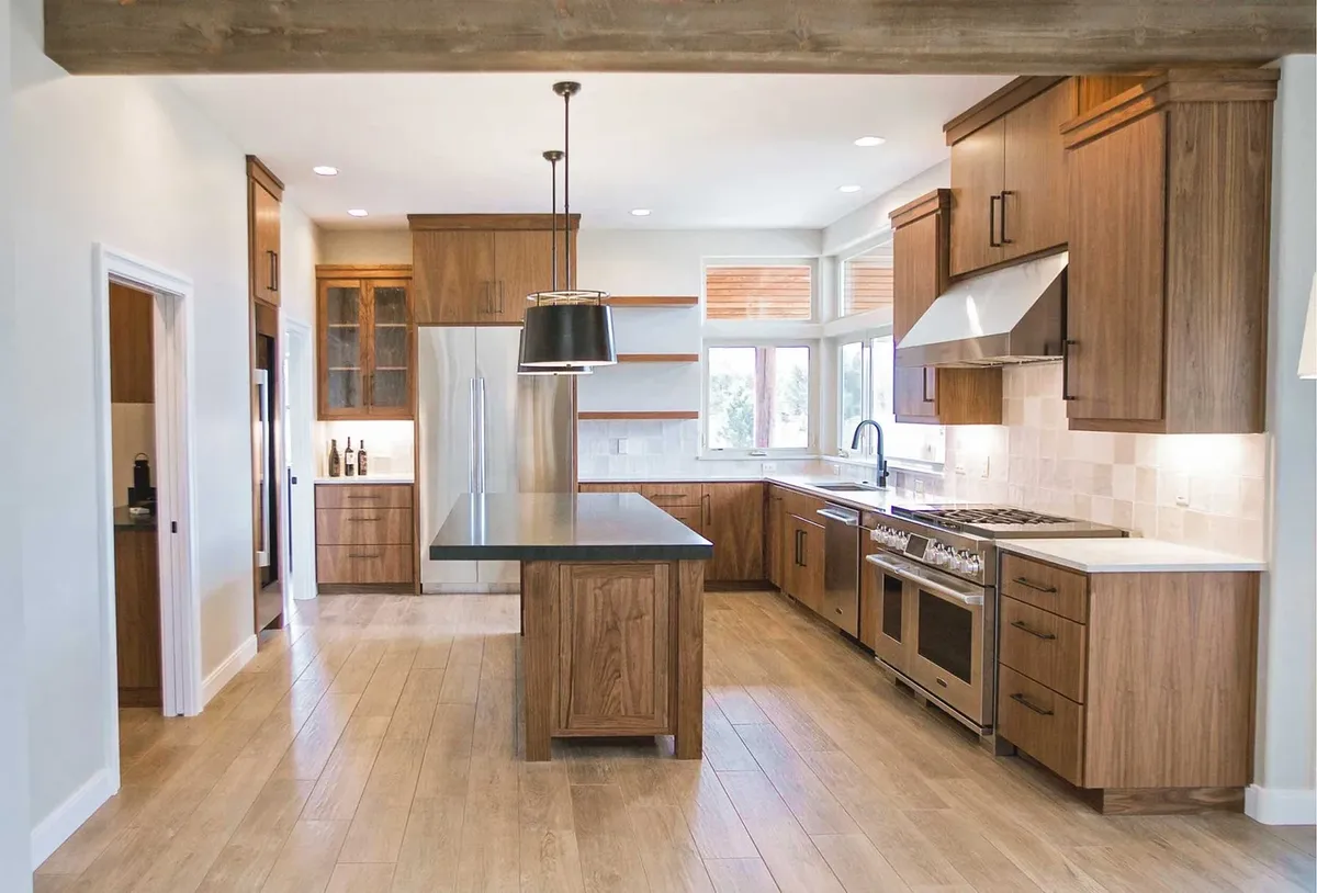 Wood kitchen with an island and pendant lights by Choice NW Construction