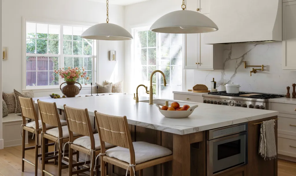 White kitchen with an island and rattan stools by Woodworx by George