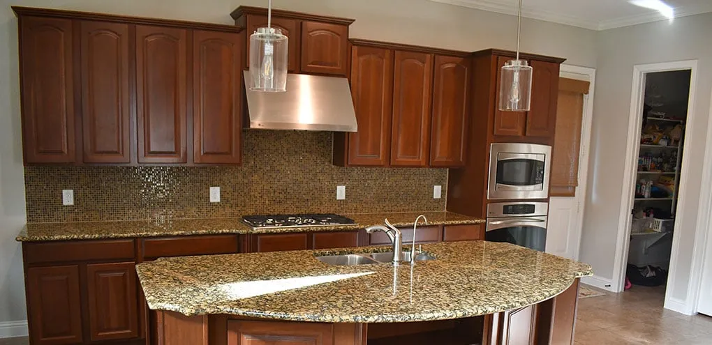 Kitchen before: dark cherry cabinets and a busy mosaic backsplash