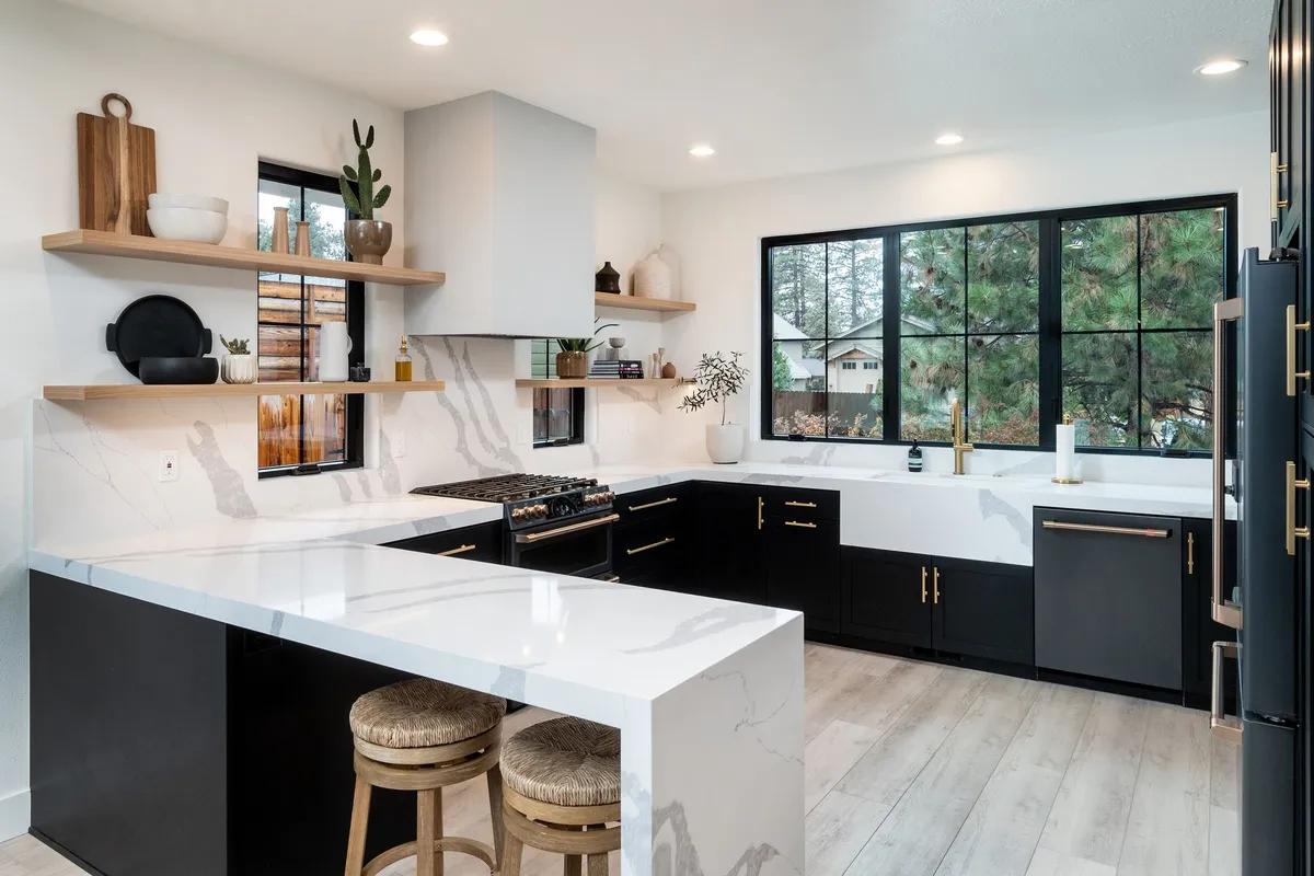 Black and white kitchen with a marble island by Montgomery Builders