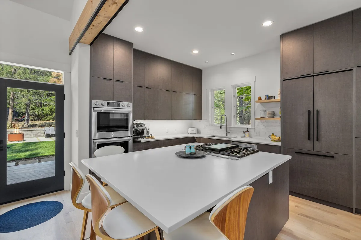 Modern gray kitchen with an island cooktop by Rockin' K GC