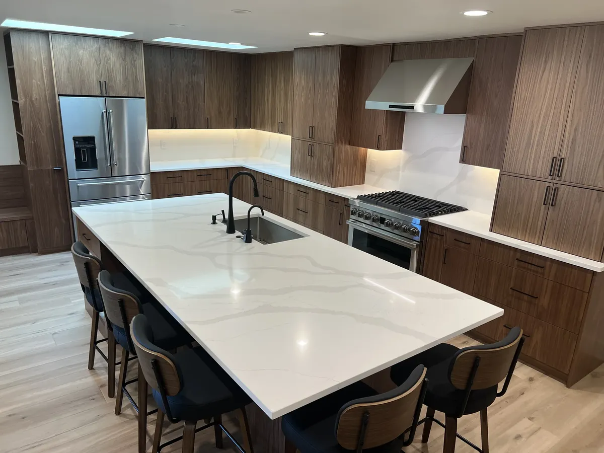 Large white quartz island with dark cabinets by Solid Rock Stone