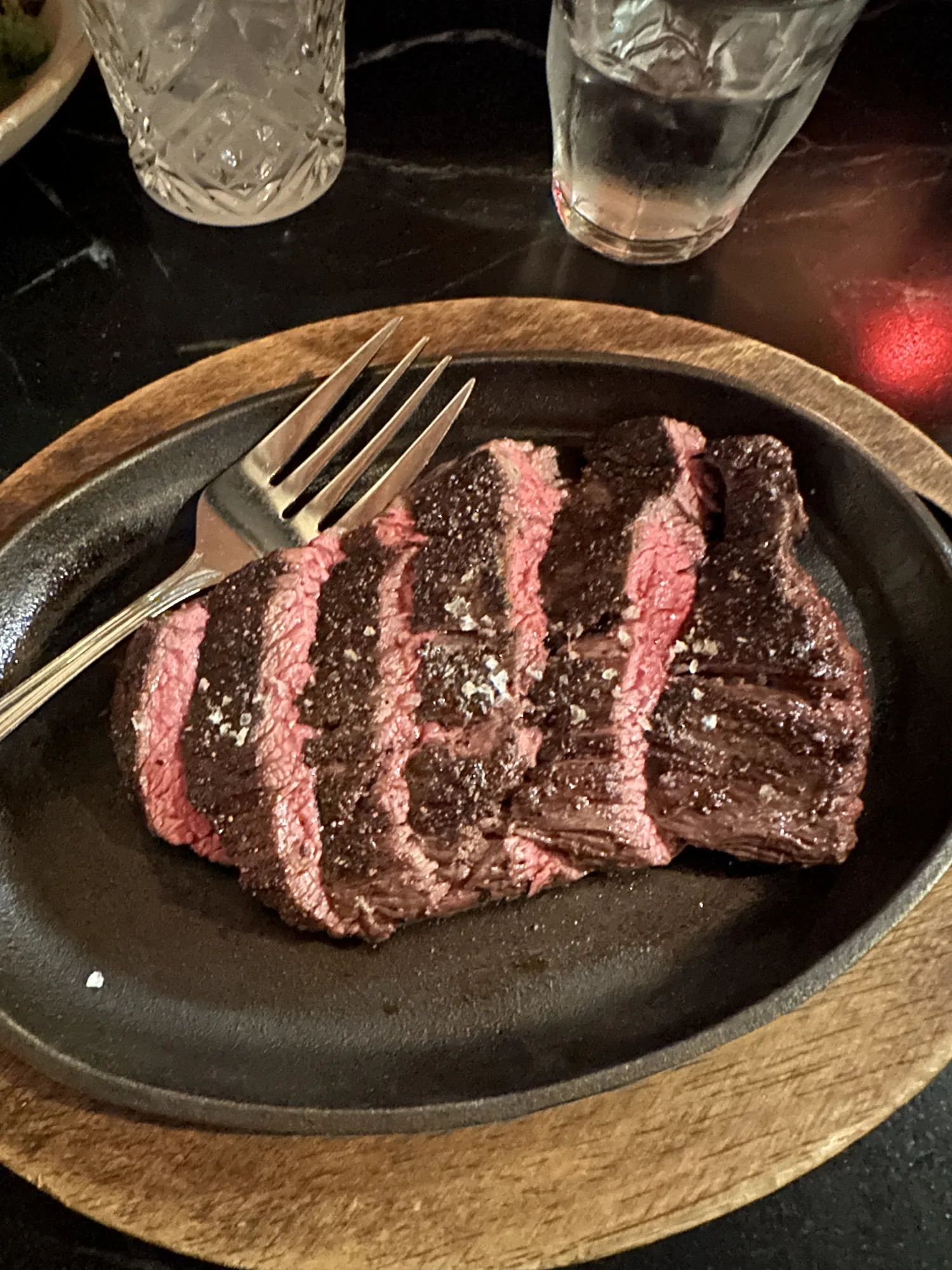 Sliced medium-rare steak on a cast-iron platter in Bend, Oregon