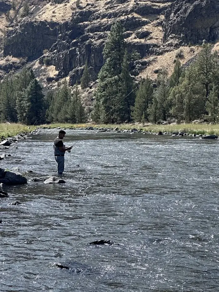 Fly fishing the Crooked River below basalt canyon walls in Central Oregon