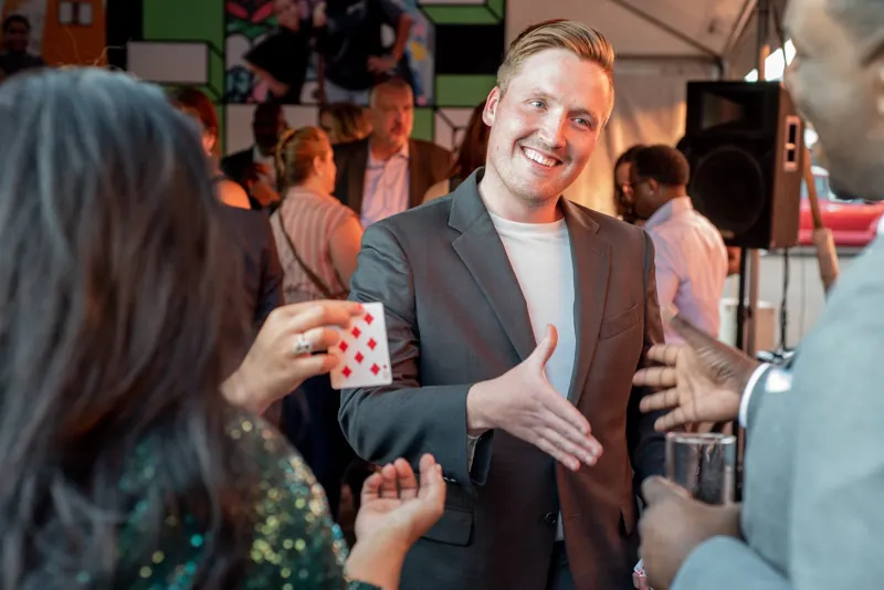 Magician Finn Joseph doing card magic for party guests