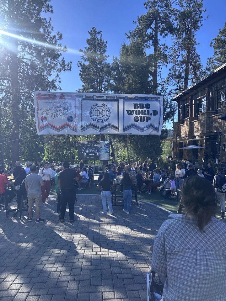 A crowd gathered under the pines at an outdoor food event in Bend