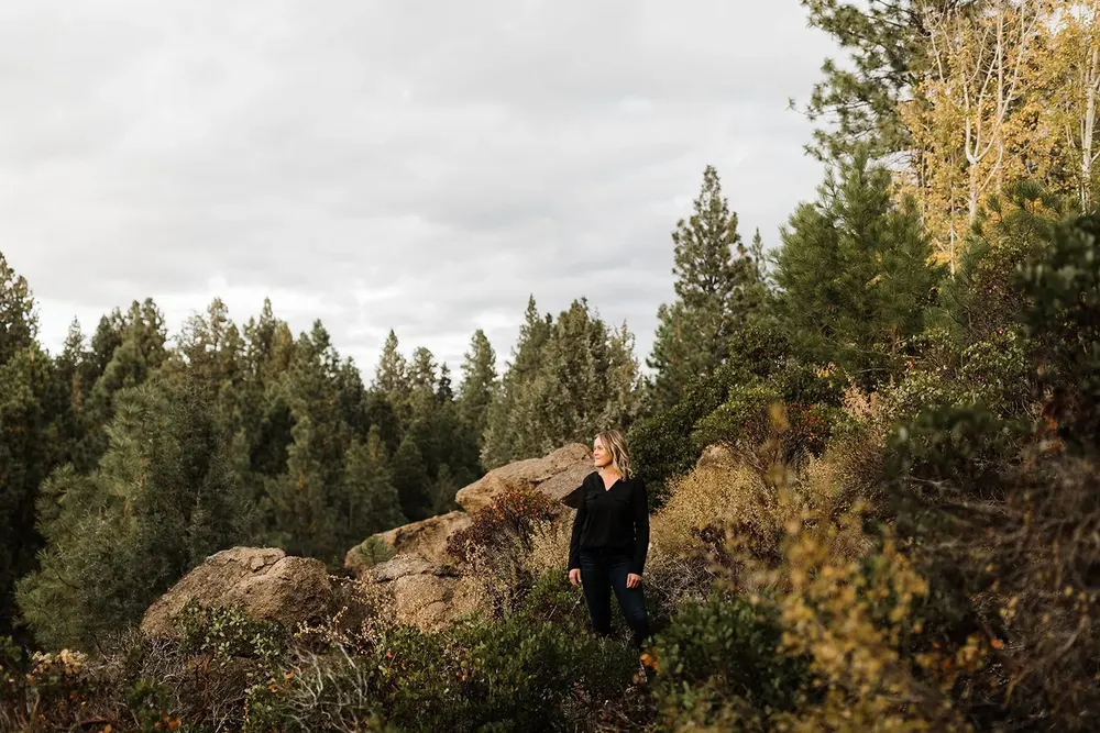 A therapist standing among junipers near Bend