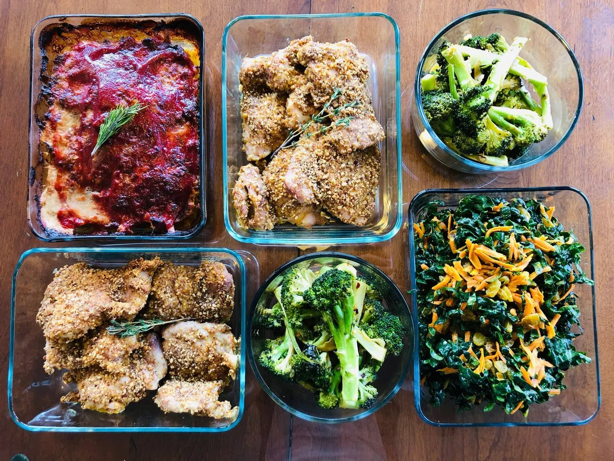 Glass dishes of chicken, greens and vegetables from Coach Tim's Healthy Meals