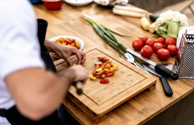 A chef chopping vegetables on a cutting board, from The Grain Collective