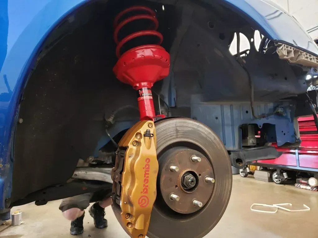 A red coilover and brake rotor on a car at Davis & Clark Auto Repair