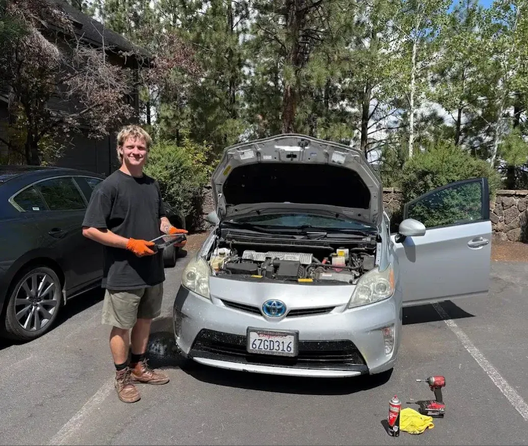 Reid working on a Toyota Prius in a driveway