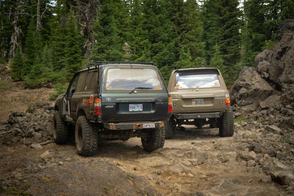 Two Toyota 4Runners parked on a cinder trail in the pines of Central Oregon