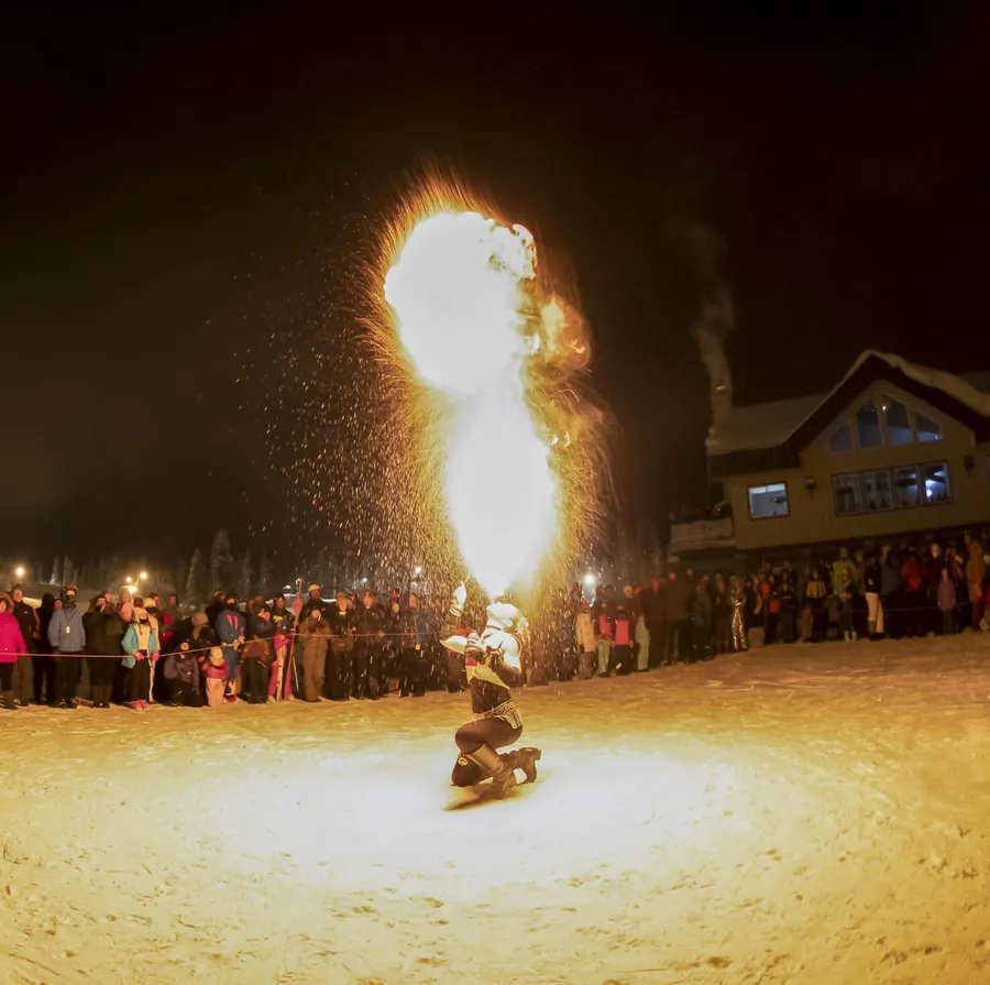 A fire dancer performing in the snow in front of a crowd at Hoodoo on New Year’s Eve