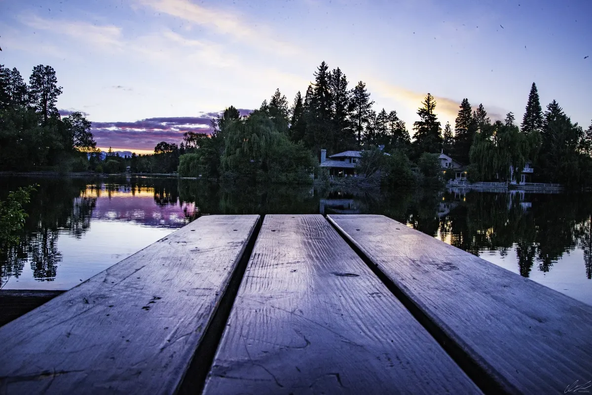 A wooden dock on a calm lake at sunset, from Elevation Property Management
