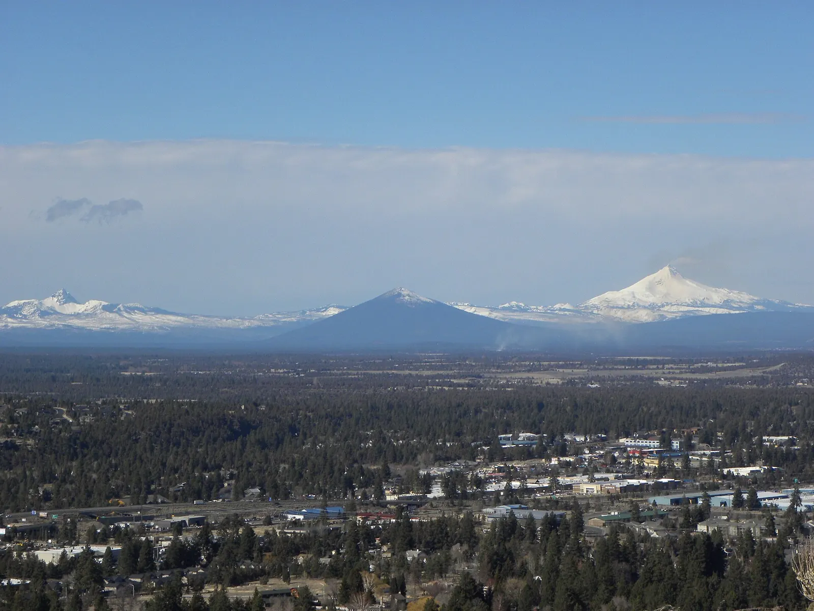 Bend's pines and rooftops below the snowy Cascades, seen from Pilot Butte