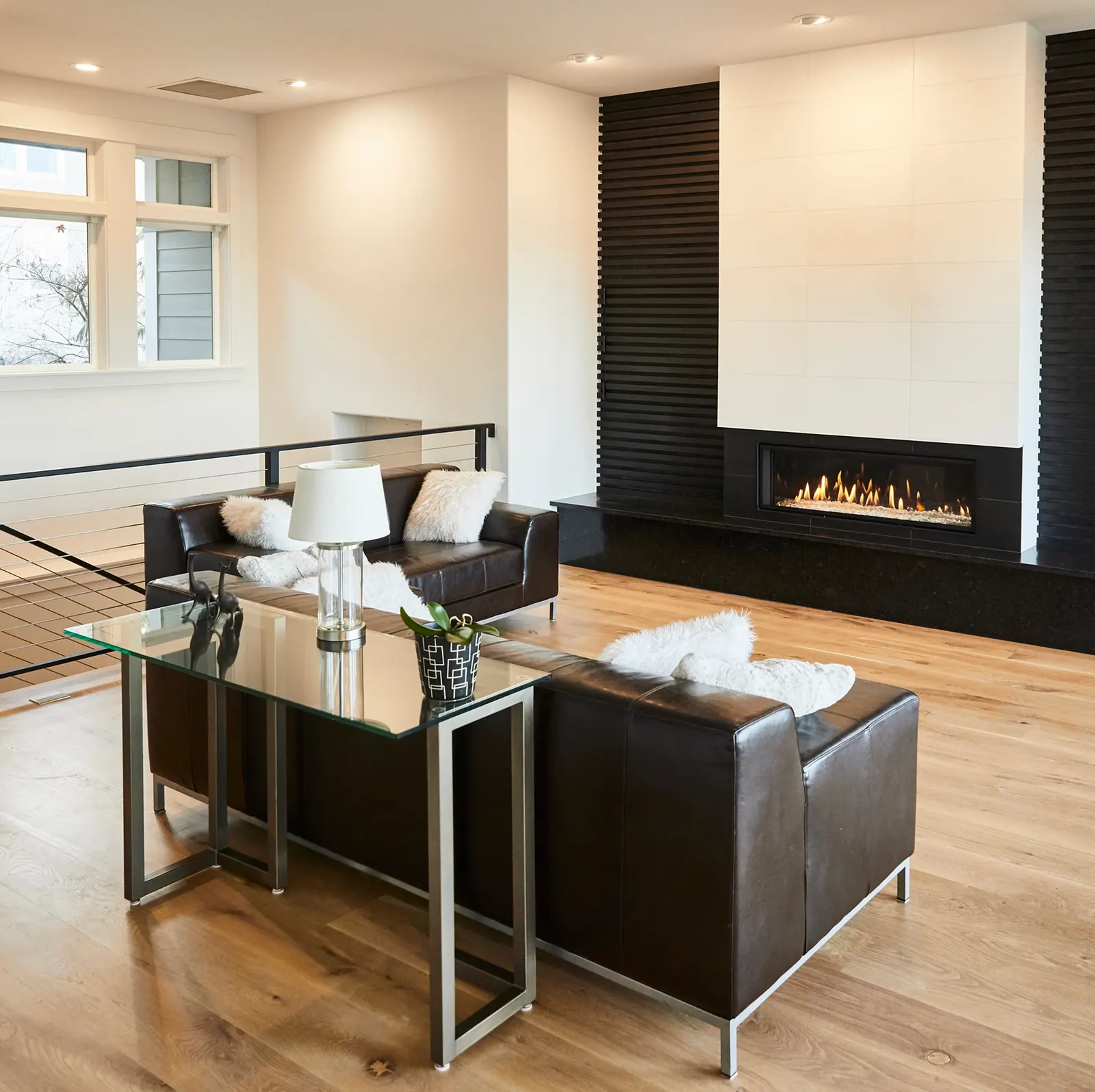 Remodeled Bend living room with a linear gas fireplace, black accent wall and leather sofas by DCR Northwest
