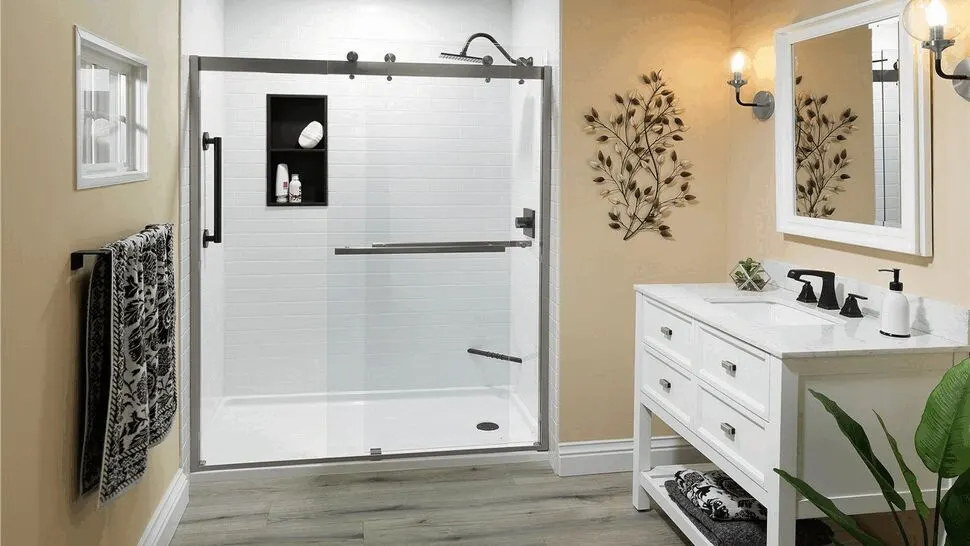 Tub-to-shower conversion with a glass slider and white wall panels by Powers Bath & Remodel