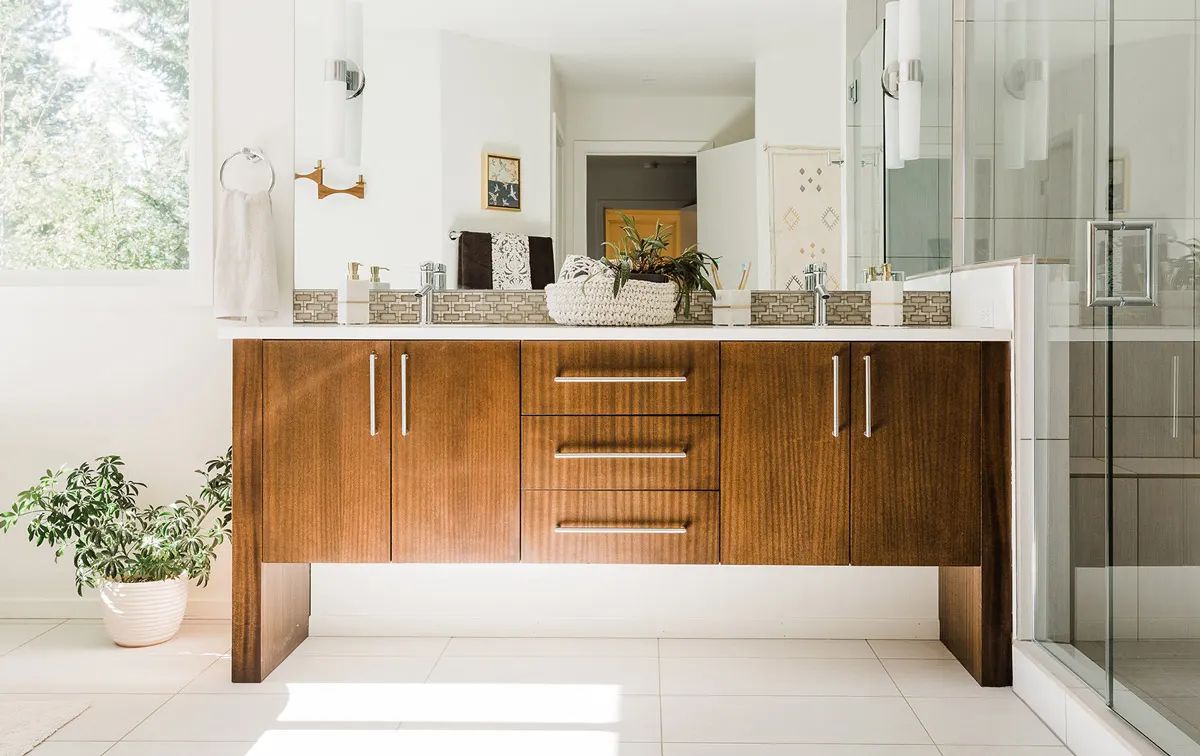 Modern bath with a floating walnut double vanity by Sierra James Construction