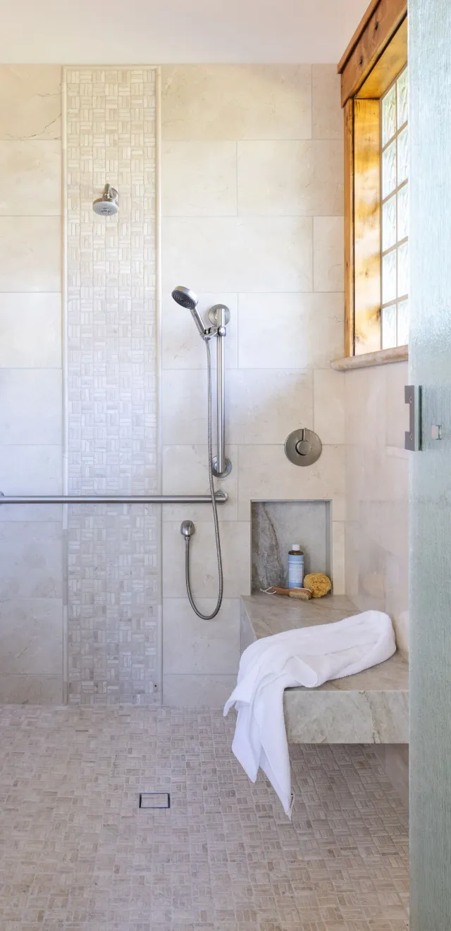 Curbless ADA shower with a linear drain and grab bar by Total Home Solutions