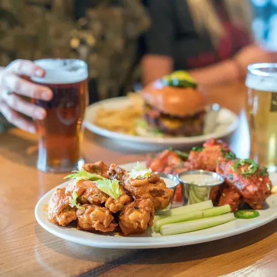 Wings, a burger and pints on a table at a 10 Barrel Brewing pub in Bend