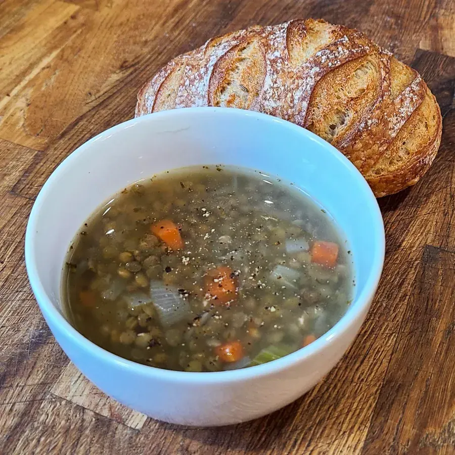 A bowl of lentil soup with a loaf of bread from A Broken Angel in Bend
