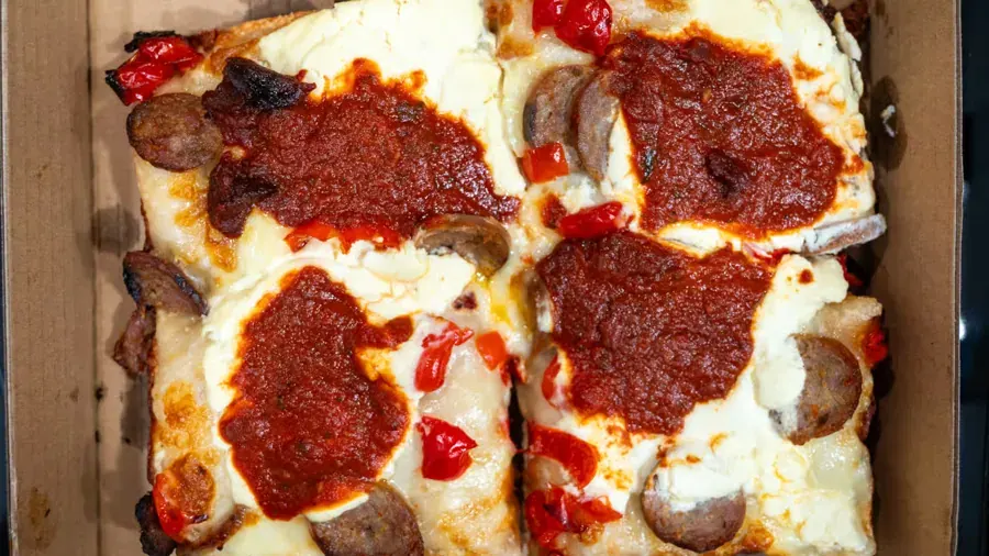 A Detroit-style pan pizza with sauce ladled on top at Abe Capanna’s in Bend
