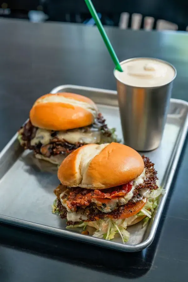Two smash burgers and a milkshake on a tray from the Americana burger truck in Bend