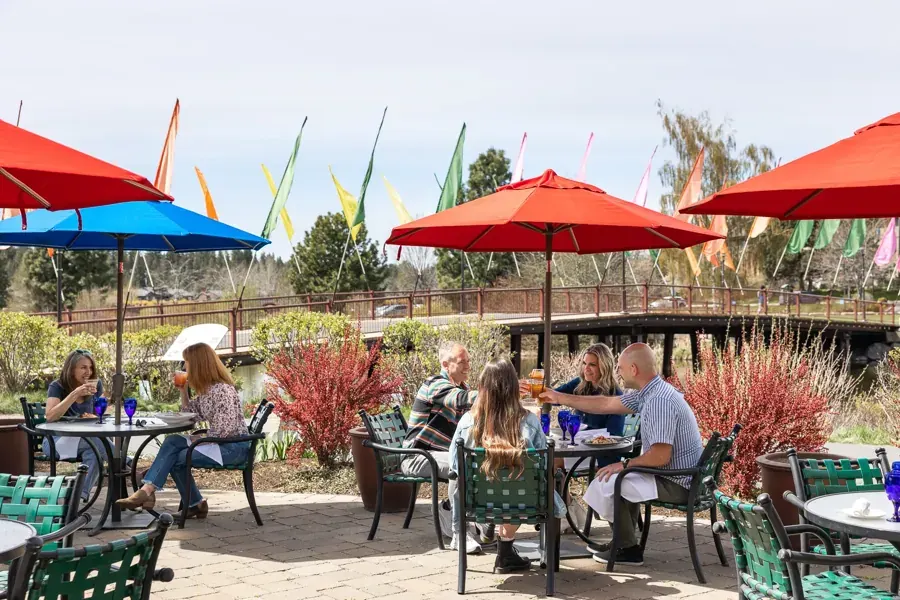 The riverside patio with red umbrellas at Anthony’s in the Old Mill District, Bend