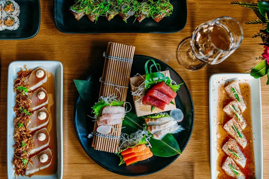 Plates of sushi rolls and sashimi at Bamboo Sushi
