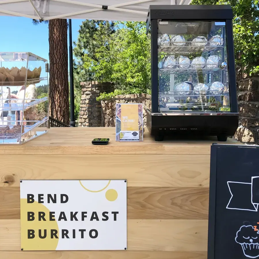 A Bend Breakfast Burrito cart with its warming case and sign