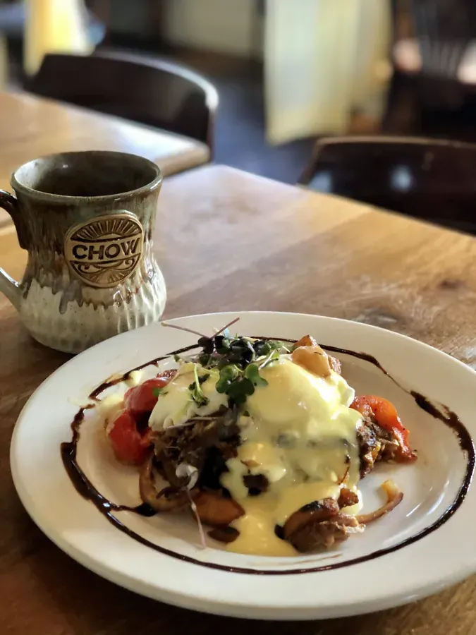 Eggs Benedict and coffee on the table at Chow on Newport Avenue in Bend