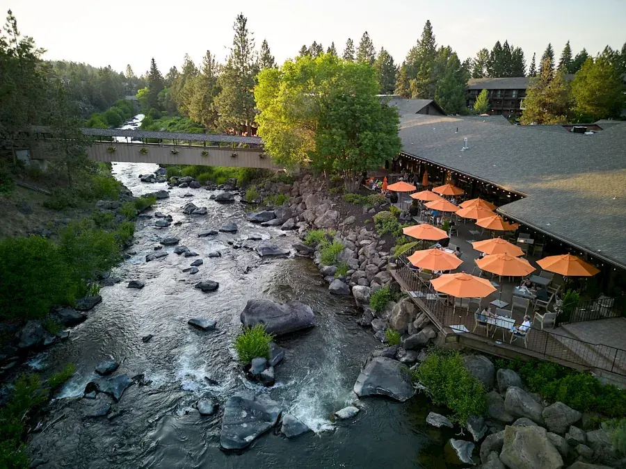 The deck with orange umbrellas above the Deschutes River at Currents at the Riverhouse in Bend