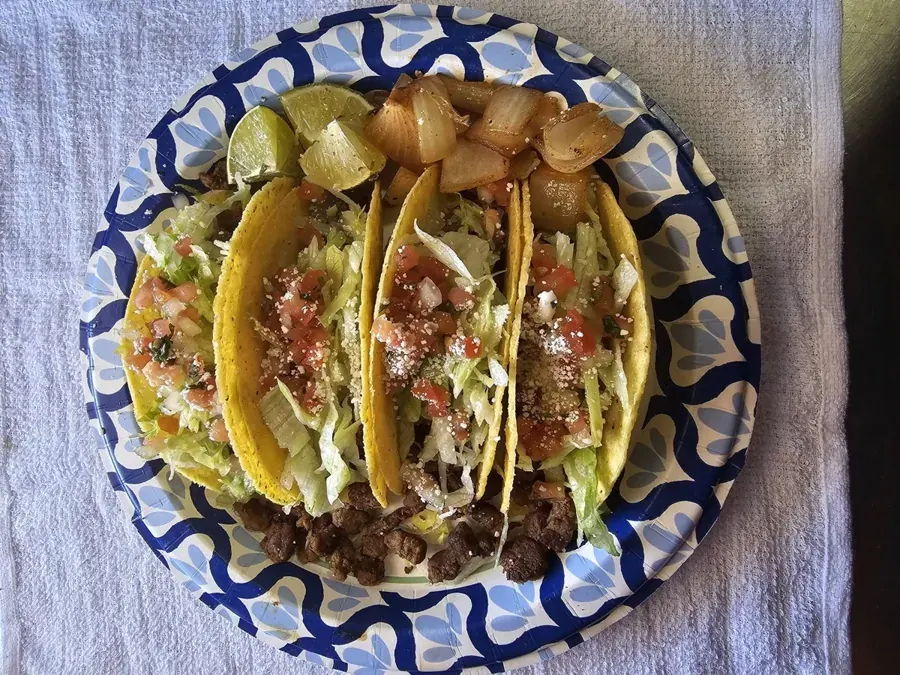 Three tacos on a blue patterned plate from the Delicias La Michoacana food truck in Bend