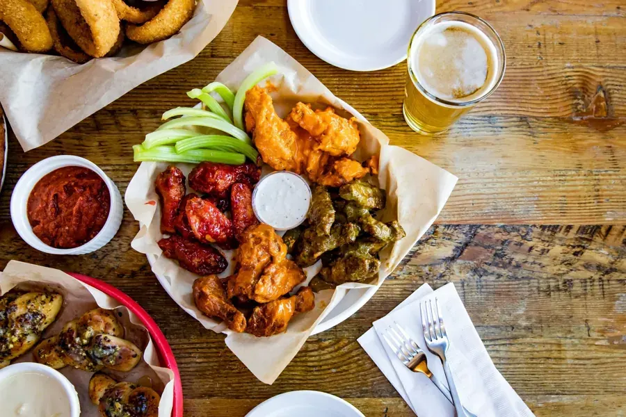 A basket of wings with dipping sauces and a beer at Fire on the Mountain in Bend