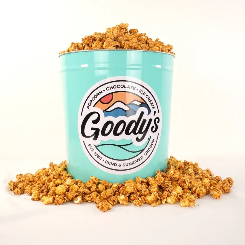 A teal Goody’s tin overflowing with caramel popcorn