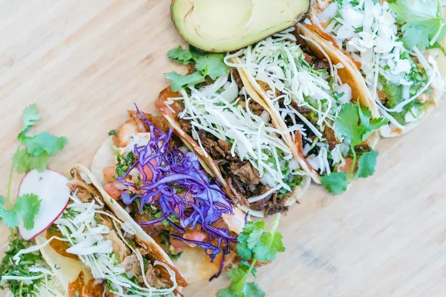A row of tacos with slaw and avocado at Hablo Tacos in Bend