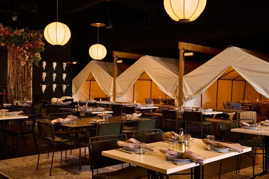 Canvas tent dining booths under paper lanterns at Hawkeye & Huckleberry Lounge on Century Drive in Bend