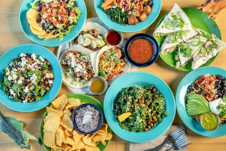 Bowls, burritos, tacos and chips on a table at Laughing Planet