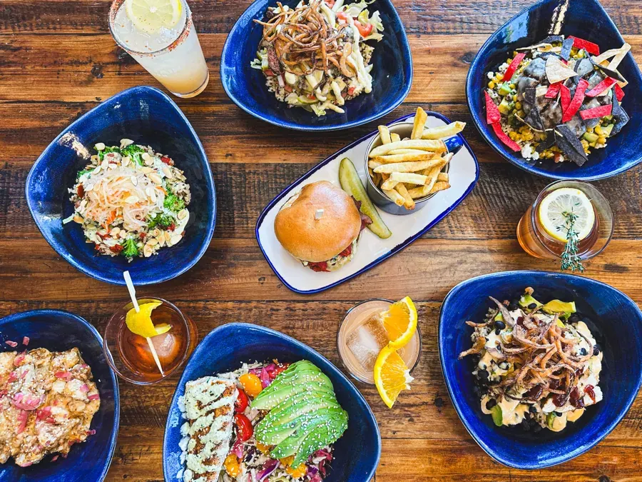 Burgers, fries and salads on blue plates at Mountain Burger in NorthWest Crossing, Bend