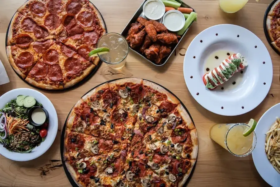 Pizzas, wings and drinks on a table at Pacific Pizza & Brew on Century Drive in Bend