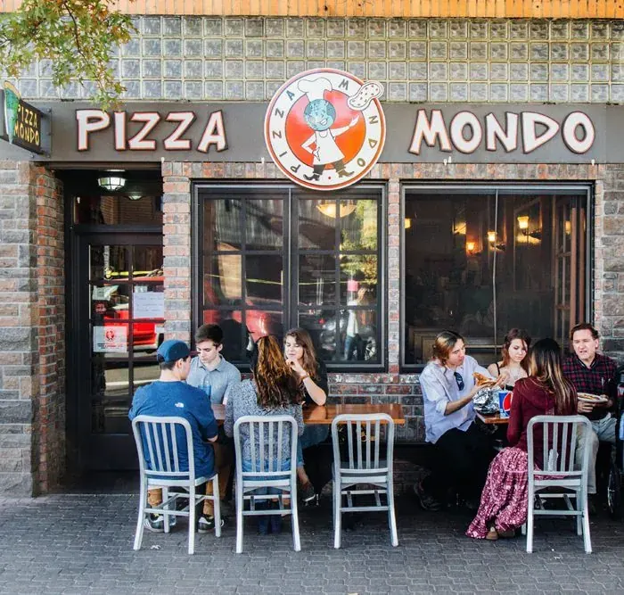 The Pizza Mondo storefront and sidewalk tables on Wall Street in downtown Bend